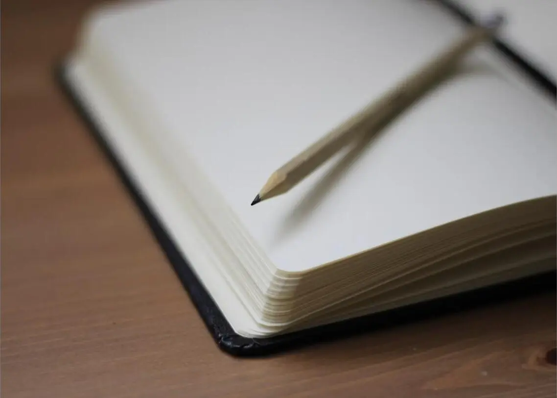 Open notitieboek met pen, symbool voor reflectie en persoonlijke ontwikkeling